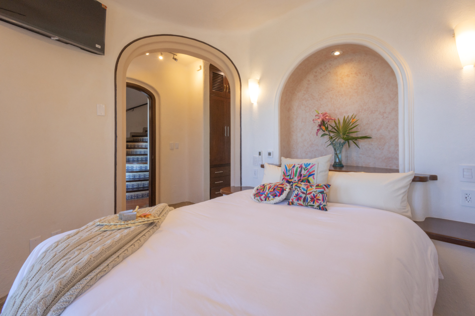 Bright and airy guest room featuring large windows with views of the tropical garden, inviting natural light into the space.
